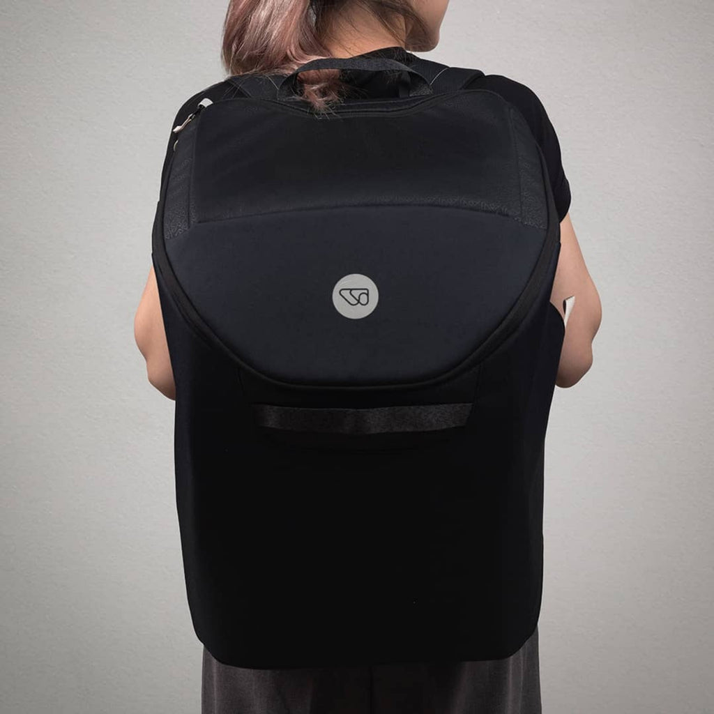 Person wearing a black WAYB Pico Car Seat Carry Bag